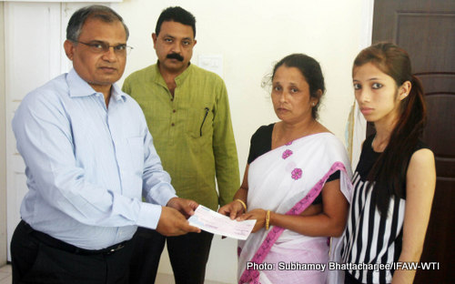 Karuna Mahanta, widow of late Naba Krishna Mahanta, FR-1 receiving the cheque of amount Rs. 50000 from IFAW-WTI  from M K Yadava, Director Kaziranga National Park at the division office on 16th October 2015. She is accompanied by her daughter Himadri Mahanta at the formal cheque handover on Friday. Photo: Subhamoy Bhattacharjee/IFAW-WTI