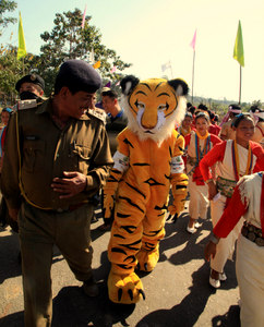 A police official admires at the mobile tiger replica supported by IFAW-WTI at Pakke Paga Festival during inaugural ceremony at Seijosa in Arunachal Pradesh on Friday,16th January 2015.Photo:Subhamoy Bhattacharjee/IFAW-WTI